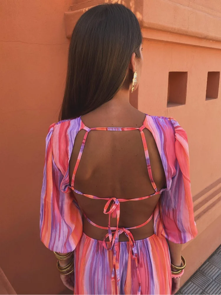 Vue arrière de la robe maxi tie-dye pour femme, mettant en valeur le dos nu avec des bretelles ajustables et un lien qui permet de personnaliser le fit. Le mélange de couleurs vives et l&
