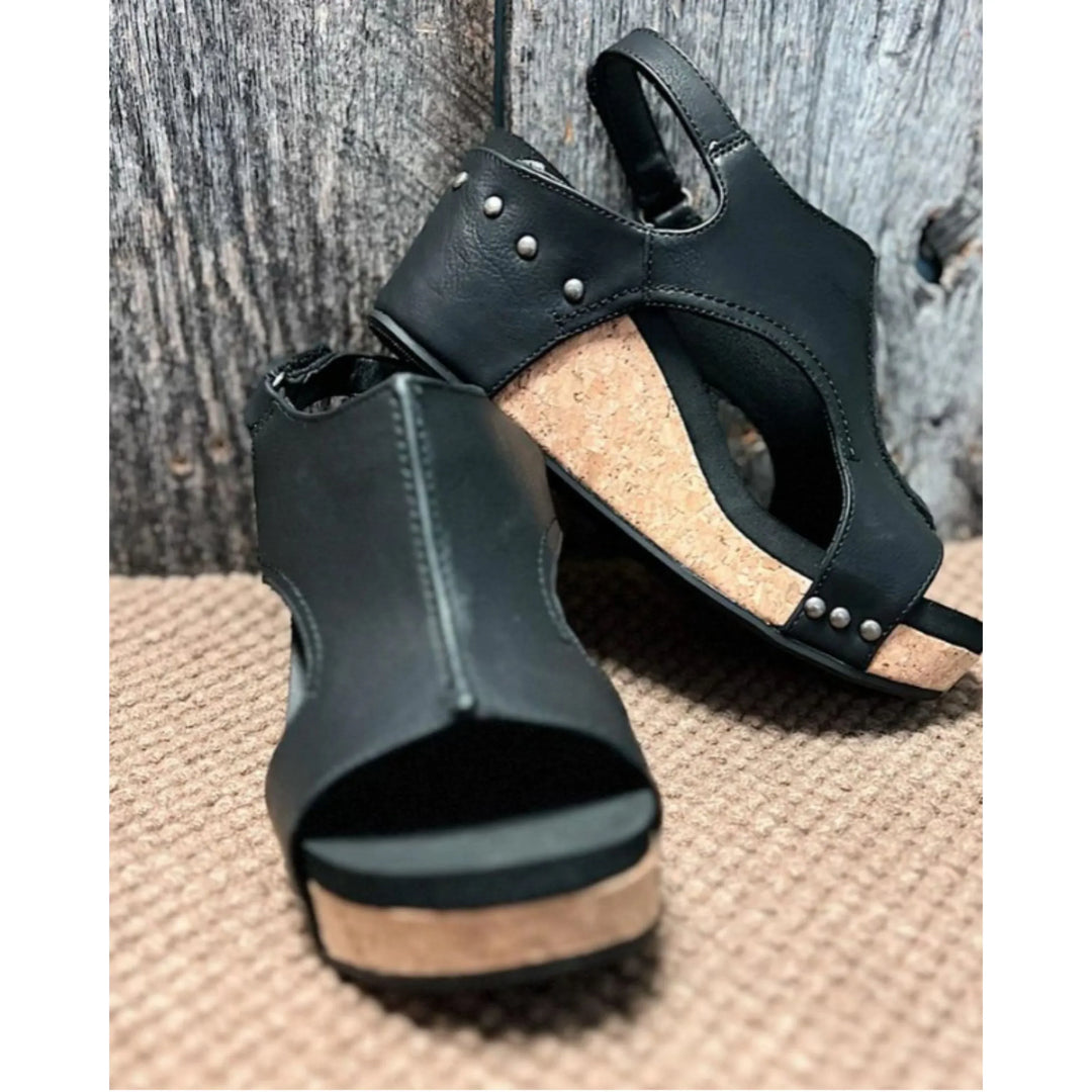 Sandales en cuir noires Elodine pour femmes avec plateforme en liège, détails cloutés et design ouvert, vue de côté.