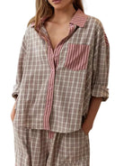 Pyjama pour femme à motif carreaux beige et rose, composé d’une chemise boutonnée oversize avec col et poche contrastés à rayures roses, assortie d’un pantalon léger. Ensemble doux, confortable et idéal pour des nuits paisibles.