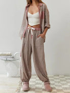 Pyjama pour femme à motif carreaux beige et rose, composé d’un pantalon ample à taille élastique et lien ruban, et d’une chemise assortie portée ouverte. Ensemble léger, doux et confortable, idéal pour des nuits paisibles ou les moments de détente.