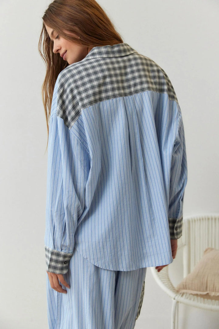 Vue arrière du pyjama femme Elowen, composé d’une chemise ample bleu clair à fines rayures, ornée d’un empiècement contrasté à carreaux gris au niveau des épaules et des poignets, assortie d’un pantalon fluide. Ensemble doux, léger et idéal pour des nuits paisibles.