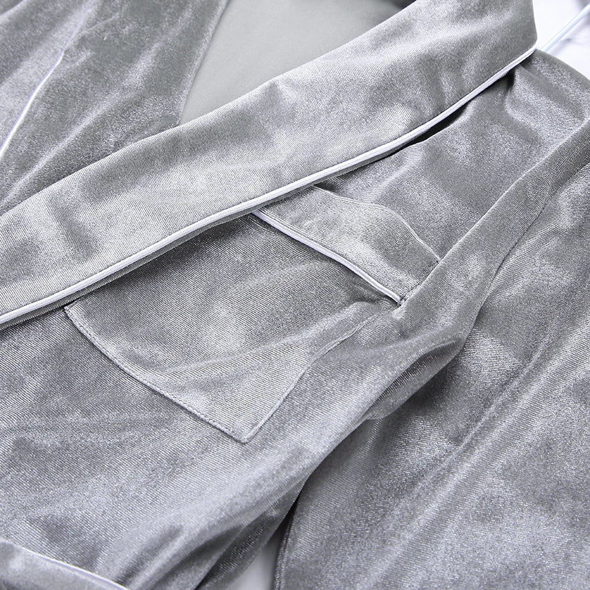 Zoom sur le pyjama femme Elysia en velours gris, mettant en valeur sa texture douce, sa poche pratique et ses finitions élégantes contrastées.