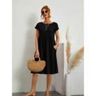 Élégante et confortable. Cette robe noire à manches courtes, avec une coupe évasée et des poches latérales, offre un style à la fois simple et chic. Accessoirisée avec un sac en osier, elle est idéale pour un look décontracté et élégant lors des journées estivales.