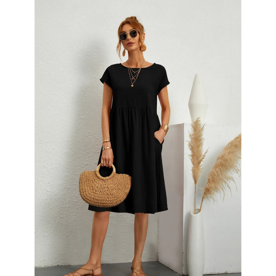 Élégante et confortable. Cette robe noire à manches courtes, avec une coupe évasée et des poches latérales, offre un style à la fois simple et chic. Accessoirisée avec un sac en osier, elle est idéale pour un look décontracté et élégant lors des journées estivales.