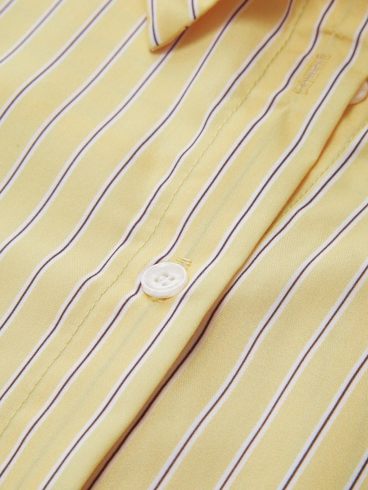 Détail de la chemise rayée Ever pour femme, tissu jaune à fines rayures avec bouton blanc, finition soignée pour un style élégant et polyvalent.