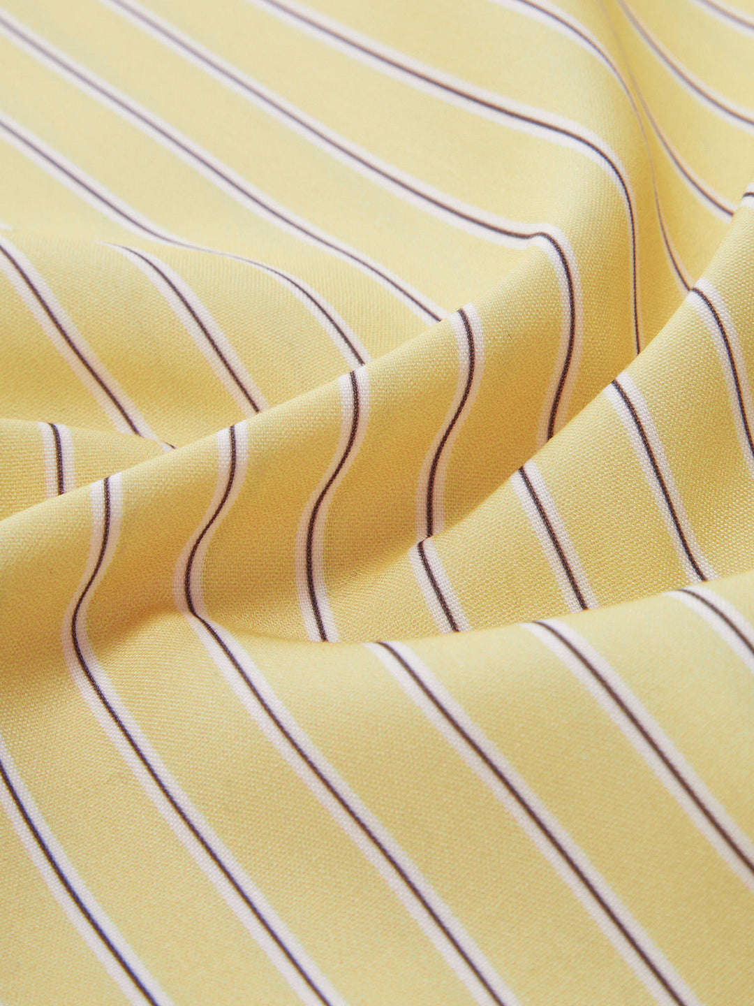 Détail du tissu de la chemise rayée Ever pour femme, jaune à fines rayures, matière légère et fluide offrant confort et élégance au quotidien.