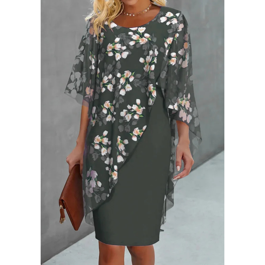 Légère et élégante, cette robe verte à corsage en mousseline orné de délicats motifs floraux offre une allure raffinée et féminine. Parfaite pour les grandes occasions, elle est accessoirisée d'une pochette en cuir marron.