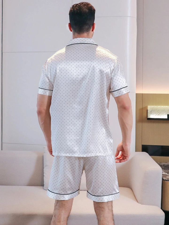 Vue de dos d’un homme portant le shorty satin pour homme Fernand, ensemble élégant et confortable composé d’une chemise à manches courtes et d’un short en satin clair à pois fins, avec finitions contrastées, offrant une coupe soignée et un tombé fluide idéal pour le confort à la maison.