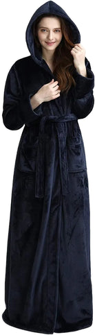 Femme souriante portant un peignoir à capuche en tissu doux de couleur bleu marine. Le peignoir long est doté d'une ceinture et de poches, offrant à la fois confort et élégance pour des moments de détente à la maison.