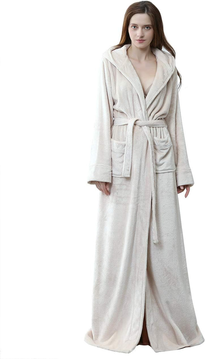 Femme portant un peignoir à capuche beige, en tissu doux, avec une ceinture et des poches. Le peignoir long et confortable est parfait pour se détendre à la maison tout en restant élégante.