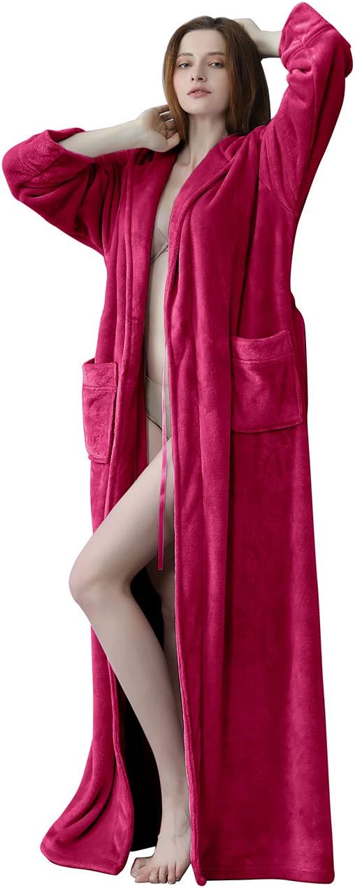 Femme debout portant un peignoir long en velours fuchsia avec des poches et une ceinture, offrant une allure élégante et un confort optimal.