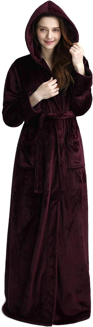 Femme souriante portant un peignoir à capuche en velours bordeaux, avec ceinture et poches, offrant confort et chaleur.