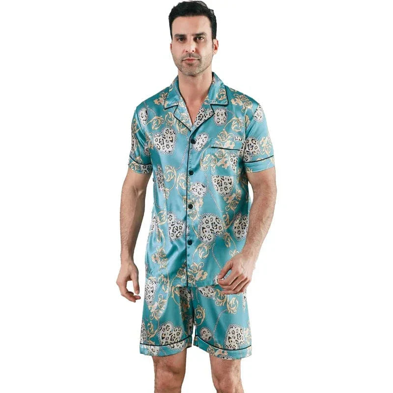 Homme portant le pyjama satin Georges pour homme, ensemble deux pièces avec chemise boutonnée à manches courtes et short assorti, imprimé décoratif vert turquoise, coupe droite, présenté sur fond blanc.