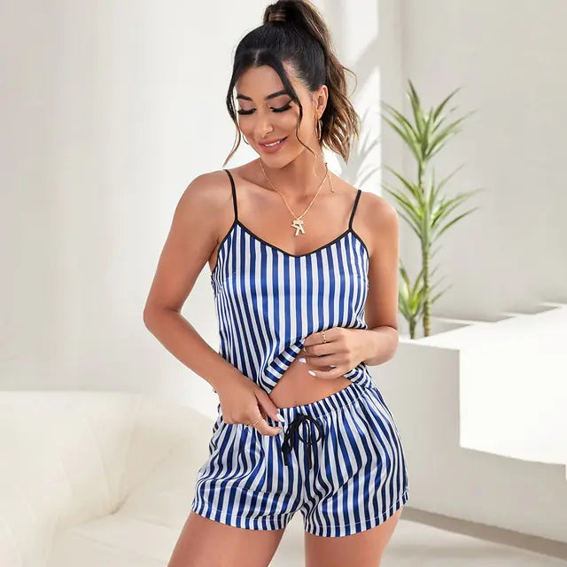 Modèle portant l’ensemble nuit femme Géraldine bleu à rayures, débardeur à fines bretelles et short assorti avec cordon de serrage, coupe légère, élégante et confortable dans un intérieur lumineux.