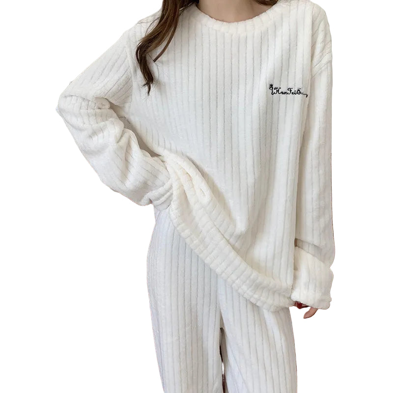 Femme portant un pyjama blanc à manches longues en tissu côtelé doux, composé d’un haut ample et d’un pantalon assorti. Ensemble confortable et élégant, parfait pour les soirées cocooning ou les journées de détente à la maison.