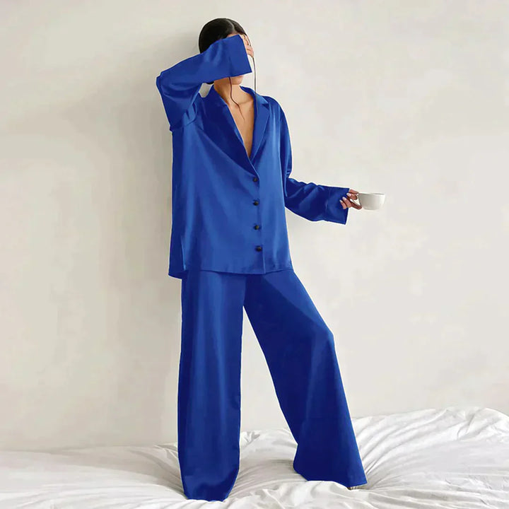 Femme portant le pyjama en coloris bleu, un ensemble élégant composé d’une chemise fluide à boutons et d’un pantalon large. Tenue douce et confortable, idéale pour la nuit et les moments de détente.