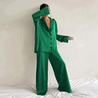 Femme portant le pyjama en coloris vert, un ensemble élégant composé d’une chemise fluide à boutons et d’un pantalon ample. Pyjama doux, chic et confortable, idéal pour la nuit et les moments de détente.