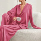 Femme portant le pyjama en coloris rose, un ensemble fluide et élégant avec chemise à col ouvert et pantalon ample. Pyjama doux, raffiné et confortable, idéal pour la nuit et les moments de détente.