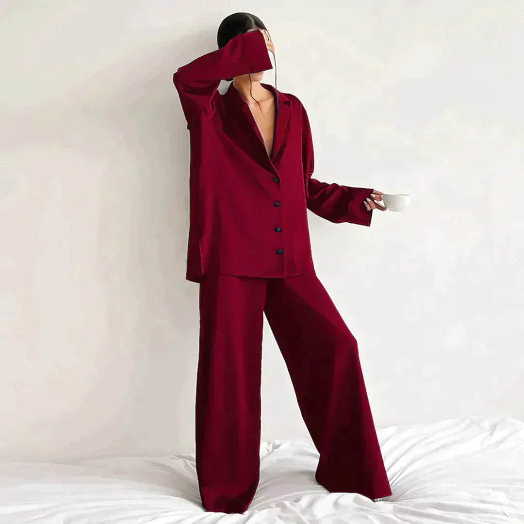 Femme portant le pyjama en coloris rouge bordeaux, un ensemble élégant composé d’une chemise fluide à boutons et d’un pantalon ample. Pyjama doux, chic et confortable, idéal pour la nuit et les moments de détente.