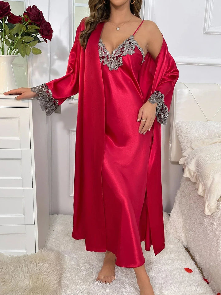 Femme portant l’ensemble Héloïse en satin rouge, composé d’une nuisette longue à fines bretelles avec broderies florales grises au décolleté, accompagnée d’un peignoir assorti avec manches longues ornées de dentelle. Lingerie élégante et agréable à porter, idéale pour les moments de détente raffinés.