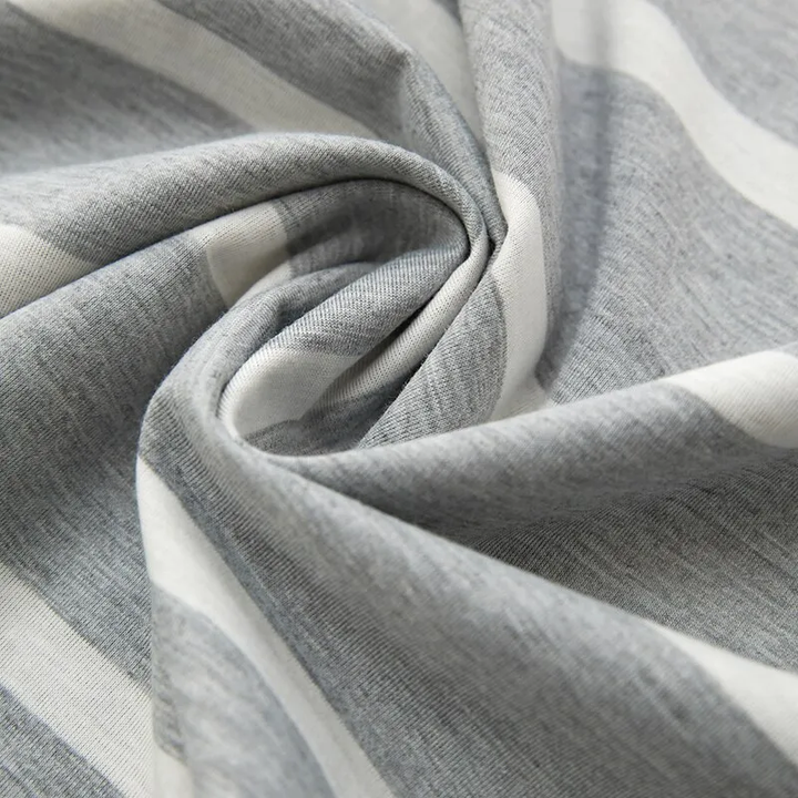 Gros plan sur le tissu du pyjama homme Henri, montrant une matière douce et légère en coton gris à rayures blanches, idéale pour un confort optimal pendant la nuit.