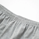 Gros plan sur la taille élastique du short du pyjama homme Henri, en tissu gris léger et doux, offrant un maintien confortable pour des nuits agréables.
