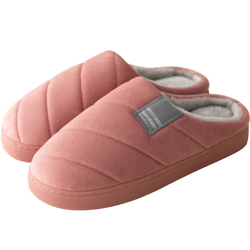 Chaussons unisexe Inaya de couleur rose, avec une texture matelassée et une doublure en fourrure douce. Confortables et chauds, parfaits pour se détendre à la maison pendant l'hiver.