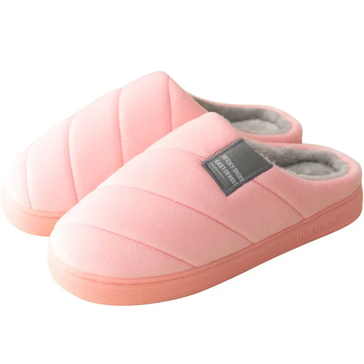 Chaussons unisexe Inaya de couleur rose pâle, avec un design matelassé et une doublure en fourrure douce. Confortables et chauds, idéaux pour se détendre à la maison pendant les mois froids.