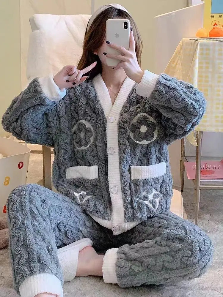 Pyjama femme Isolde en polaire grise ultra-douce, composé d’une veste boutonnée avec bordures blanches et motifs décoratifs, assortie d’un pantalon chaud et moelleux. Ensemble confortable idéal pour cocooner à la maison.