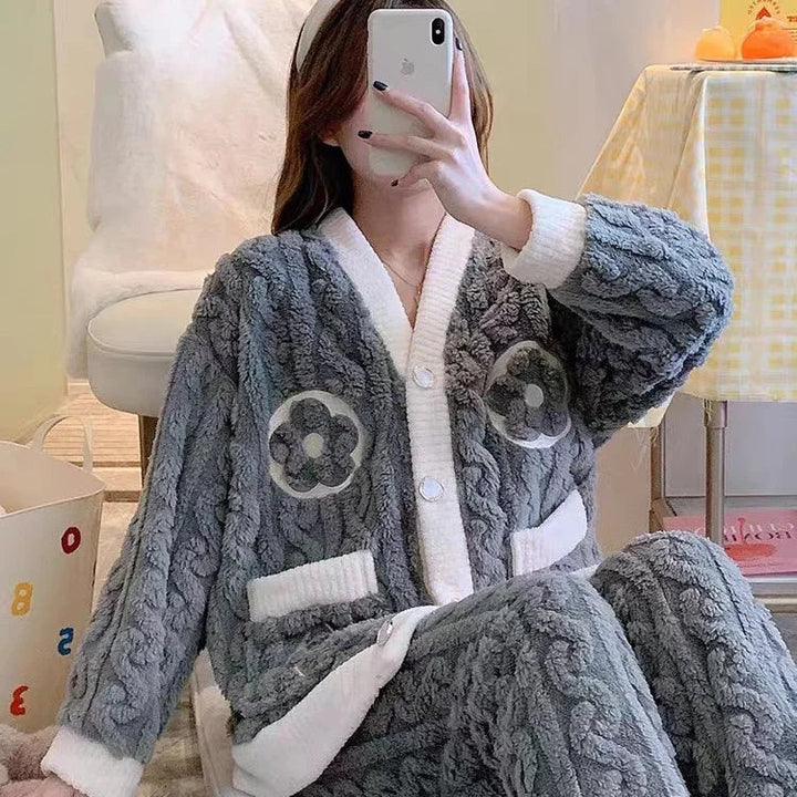 Pyjama femme Isolde en polaire grise ultra-douce, composé d’une veste boutonnée avec bordures blanches et motifs floraux, assortie d’un pantalon chaud et confortable. Tenue cocooning parfaite pour l’hiver.