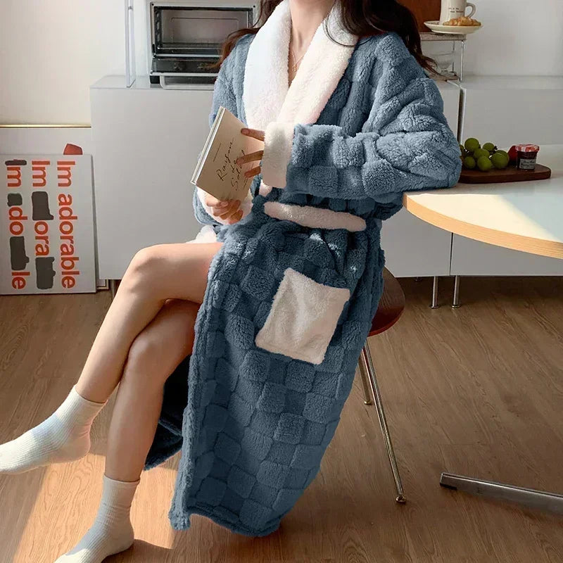 un peignoir long bleu à texture quadrillée avec col, poignets et poches en fausse fourrure blanche, idéal pour offrir douceur et chaleur pendant l’hiver.