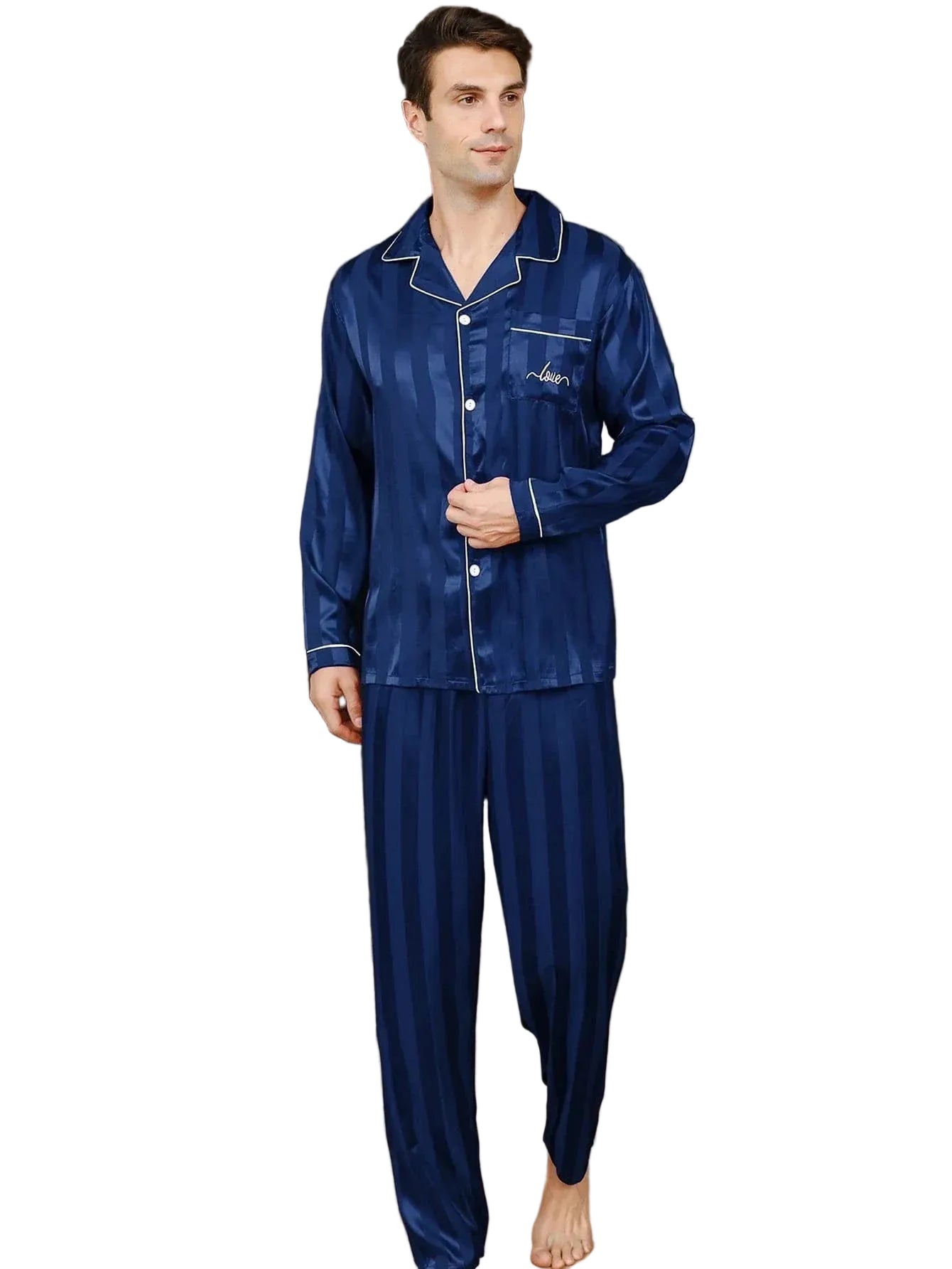 Homme debout dans un intérieur moderne portant le pyjama satin pour homme Jérôme, ensemble élégant et confortable composé d’une chemise à manches longues boutonnée et d’un pantalon assorti, en satin bleu à fines rayures avec finitions contrastées, offrant une allure raffinée et un confort optimal pour la nuit ou la détente à la maison.