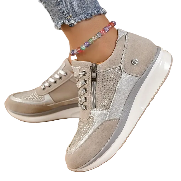 Chaussures modernes et confortables pour femmes, avec une finition en cuir suédé beige et des détails métalliques argentés. Design élégant et pratique, avec une fermeture éclair sur le côté et des lacets pour un ajustement parfait. Parfaites pour un look tendance tout en offrant un confort optimal au quotidien.