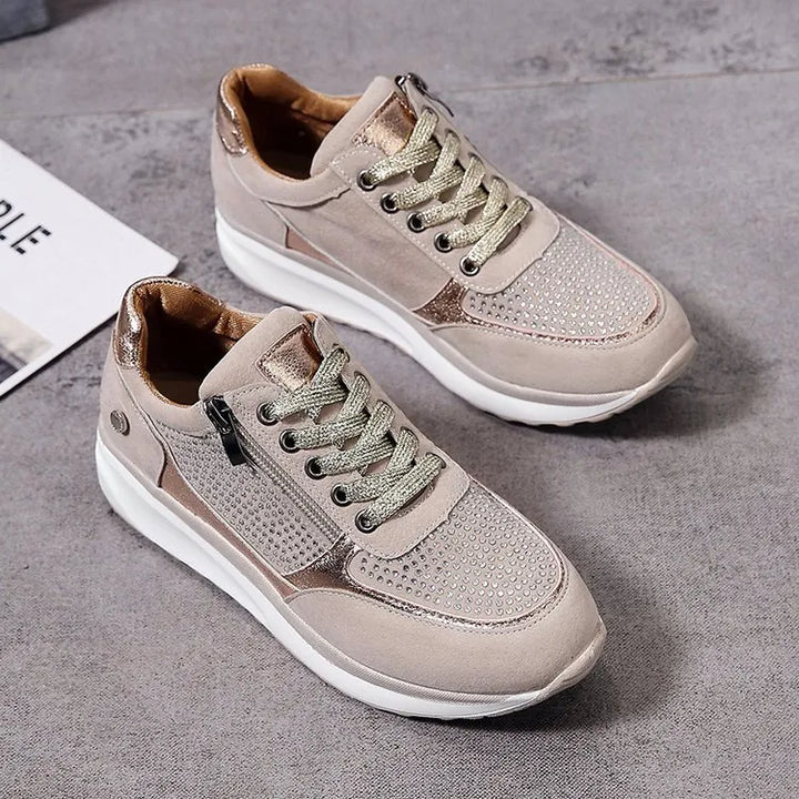 Optez pour ces baskets élégantes et confortables pour femme, alliant cuir suédé beige et détails métalliques dorés. Avec des perforations sur le dessus pour un style moderne et une fermeture éclair latérale pour un ajustement pratique. Parfaites pour un look décontracté et tendance tout en garantissant un confort au quotidien.