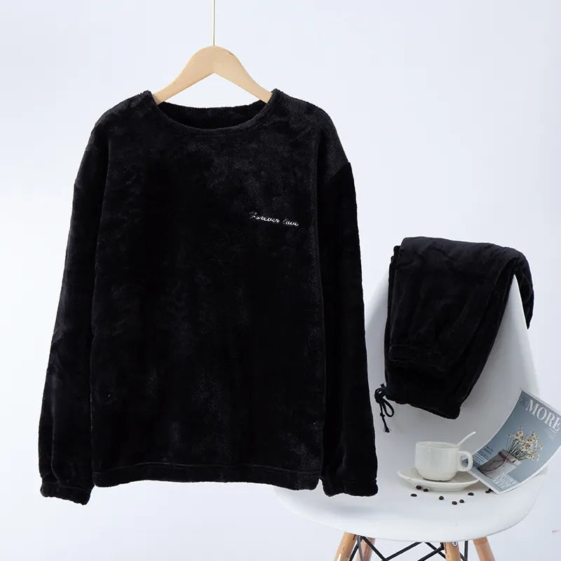 Pyjama en flanelle pour homme composé d’un haut à manches longues bleu marine suspendu sur cintre et d’un pantalon assorti posé sur une chaise. Ensemble chaud, doux et très confortable, idéal pour l’hiver et les moments cocooning.