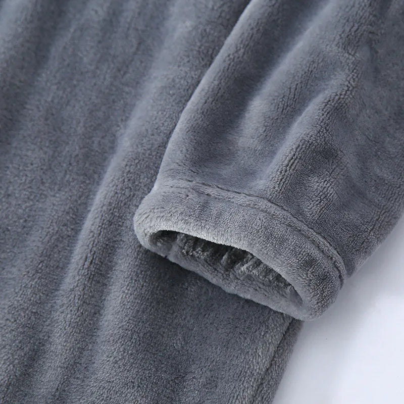 Gros plan sur la manche d’un pyjama en flanelle pour homme, en tissu gris ultra doux et moelleux. Finition chaude et confortable idéale pour l’hiver et les moments de détente à la maison.