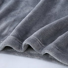 Gros plan sur l’ourlet d’un pyjama en flanelle pour homme, en tissu gris ultra doux, épais et moelleux. Matière chaude et confortable, parfaite pour l’hiver et les moments cocooning.