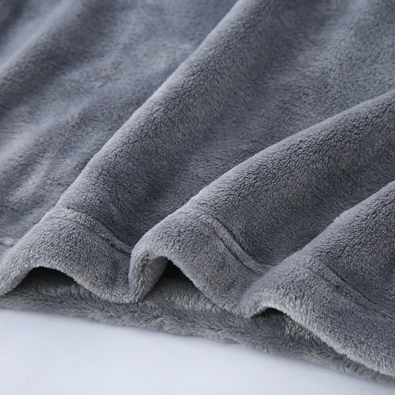 Gros plan sur l’ourlet d’un pyjama en flanelle pour homme, en tissu gris ultra doux, épais et moelleux. Matière chaude et confortable, parfaite pour l’hiver et les moments cocooning.