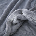 Gros plan sur la texture du pyjama en flanelle pour homme, montrant un tissu gris épais, ultra doux et moelleux, idéal pour offrir chaleur et confort durant l’hiver.