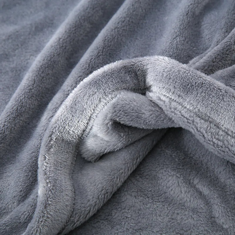 Gros plan sur la texture du pyjama en flanelle pour homme, montrant un tissu gris épais, ultra doux et moelleux, idéal pour offrir chaleur et confort durant l’hiver.