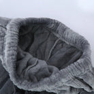 Gros plan sur l’intérieur du pantalon d’un pyjama en flanelle pour homme, en tissu gris épais, ultra doux et moelleux. Taille élastiquée offrant confort, chaleur et maintien, idéale pour l’hiver.