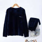 Pyjama en flanelle pour homme composé d’un haut noir à manches longues suspendu sur cintre et d’un pantalon assorti posé sur une chaise. Ensemble chaud, doux et très confortable, idéal pour l’hiver et les moments de détente à la maison.