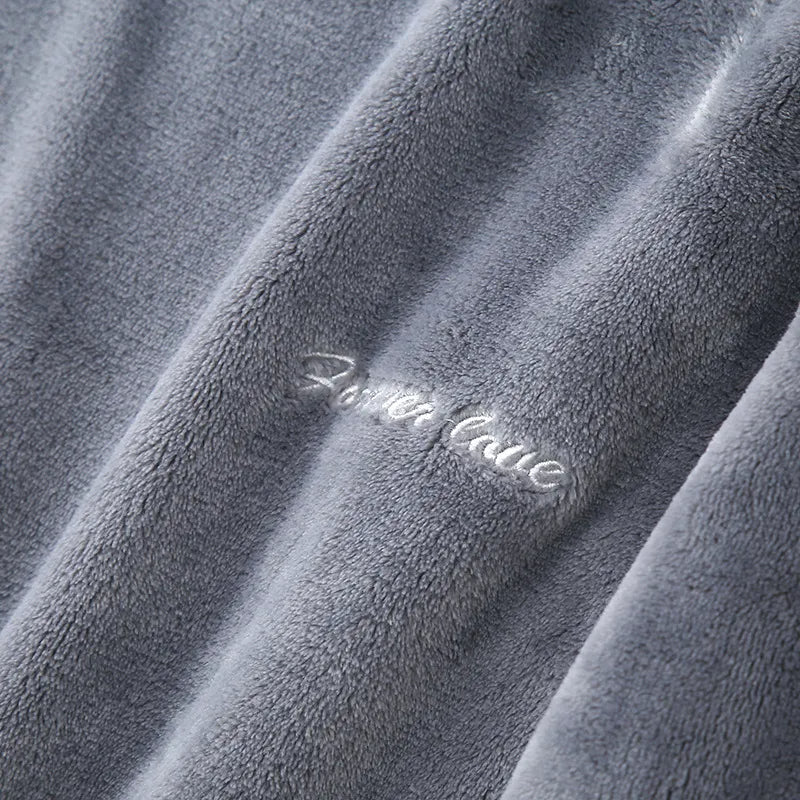 Gros plan sur la matière du pyjama en flanelle pour homme, en tissu gris ultra doux avec broderie “Forever love”. Texture chaude, moelleuse et très confortable, parfaite pour l’hiver.