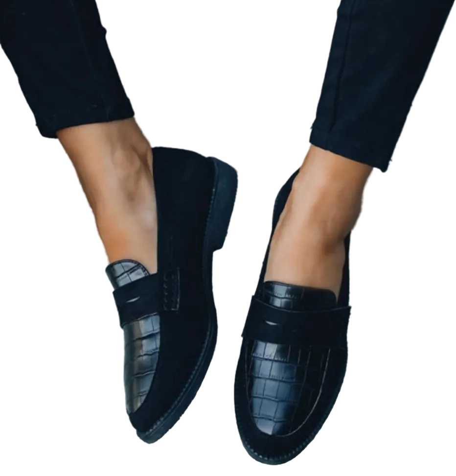 Mocassins femme élégants et confortables noirs, dessus effet croco et bandeau style penny loafer, portés avec pantalon noir, vue de dessus.