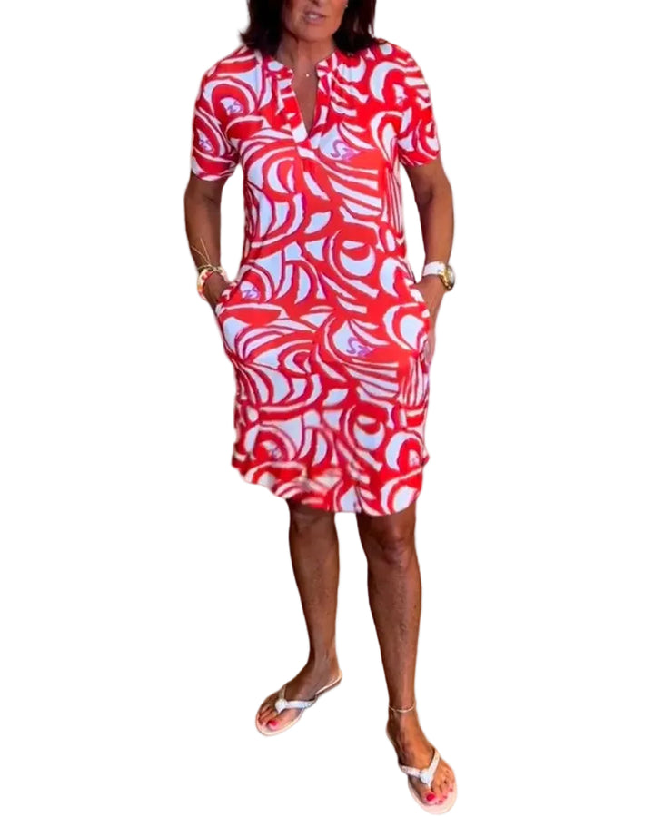 Modèle portant la robe mini Joie, au motif abstrait en rouge et blanc, parfaite pour l&