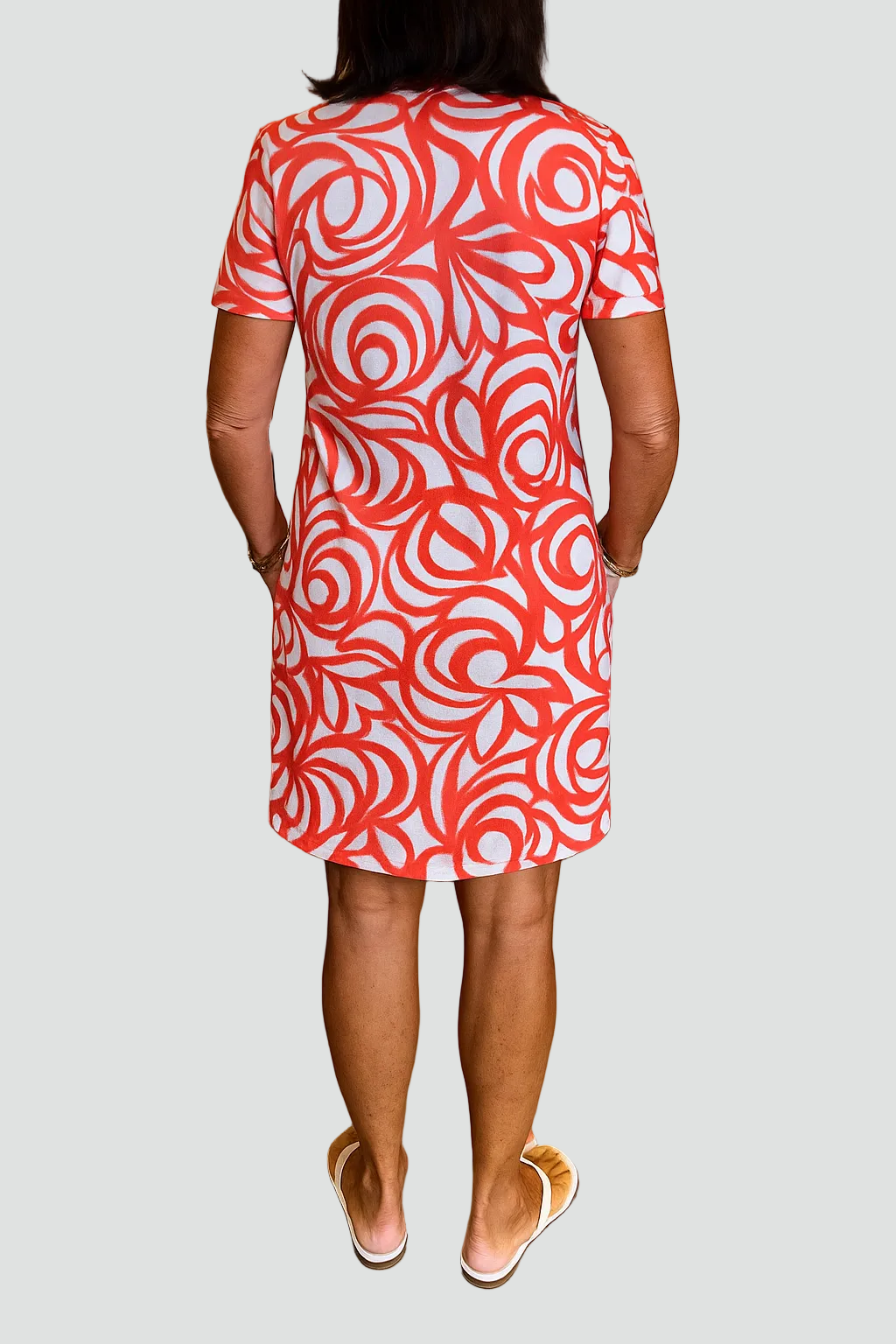 Vue arrière du modèle portant la robe mini Joie avec un imprimé abstrait rouge et blanc. Cette robe légère et tendance, dotée de poches pratiques, est parfaite pour l&