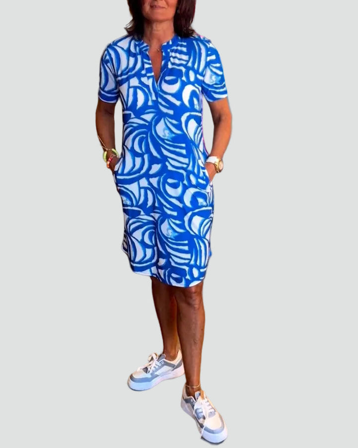 Modèle portant la robe mini Joie avec un imprimé abstrait bleu et blanc, un choix tendance et léger pour l&