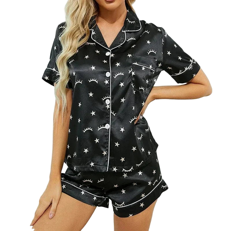 Femme portant le pyjama en satin pour femme : léger, élégant et parfait pour la nuit, un ensemble en satin noir composé d'une chemise à manches courtes et d'un short, orné d'étoiles et de motifs de cils, offrant confort et style pour des nuits douces.