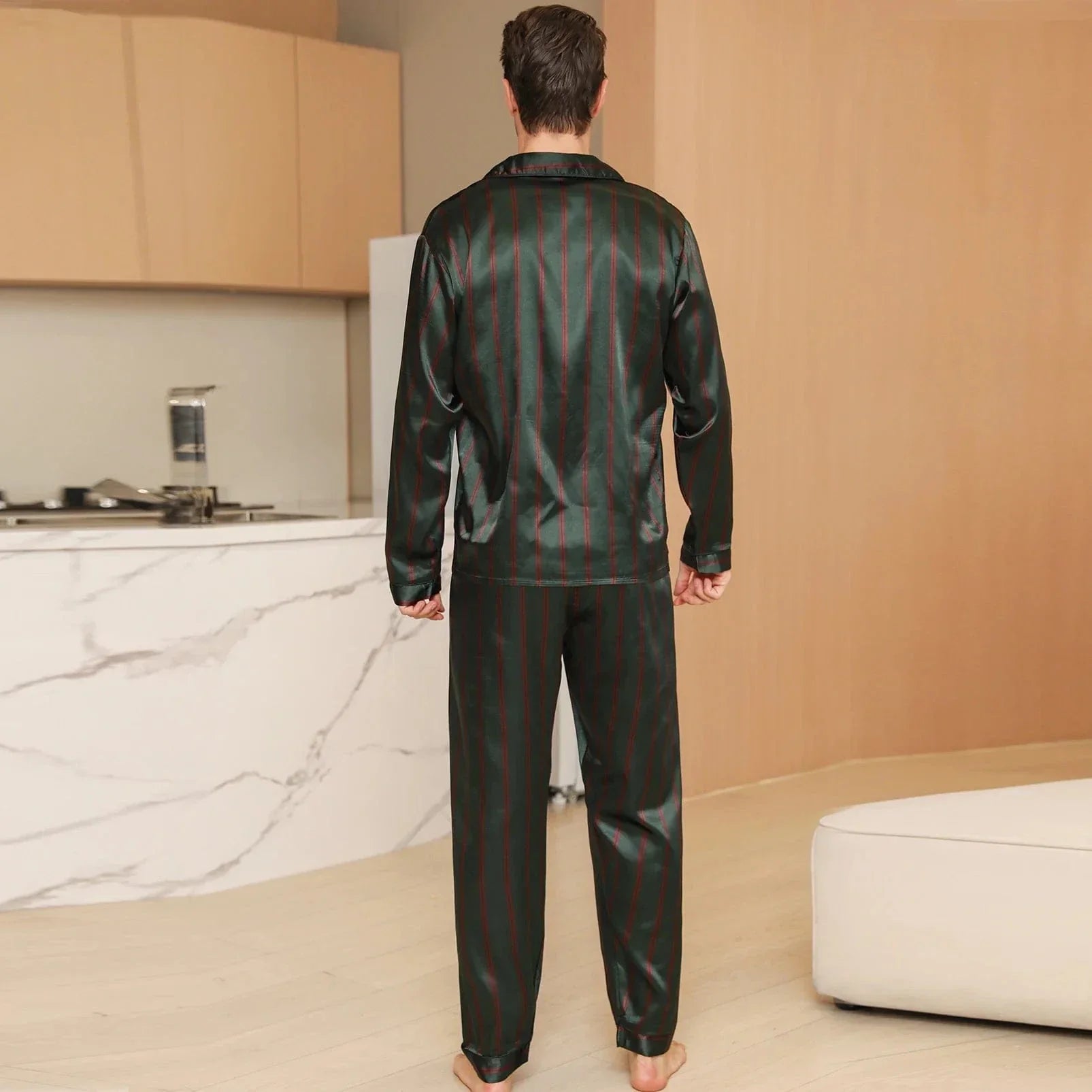 Vue de dos d’un homme portant le pyjama satin pour homme Julien, ensemble léger et agréable composé d’une chemise à manches longues et d’un pantalon assorti, en satin vert à fines rayures rouges, offrant une coupe soignée et un tombé fluide idéal pour la nuit ou la détente à la maison.