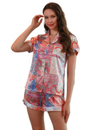 Femme souriante portant le shorty Juliette, un ensemble estival composé d’un haut à manches courtes et d’un short fluide en satin imprimé de motifs cachemire multicolores. Pyjama léger et élégant, parfait pour les nuits chaudes ou les matinées détendues. Tissu soyeux et agréable au toucher.